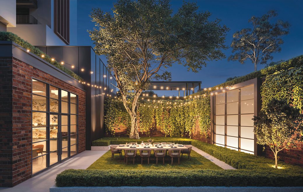 Hudson Place Residences courtyard garden at night with string lights and outdoor dining